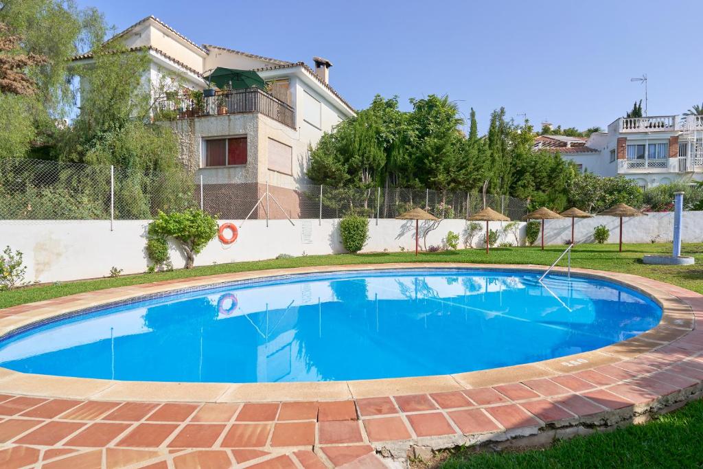 Una gran piscina azul frente a una casa en Casa Alina, en Nerja