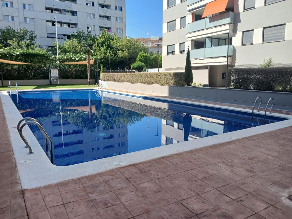 a swimming pool in a building with its reflection in the water at Tikitita House in Gandía