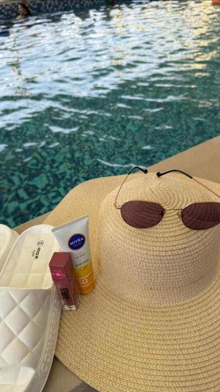 艾恩استراحة دار العين的游泳池旁的草帽和太阳镜