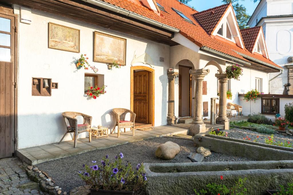 a house with two chairs and a patio at Penzion U Zámeckého parku in Žihobce