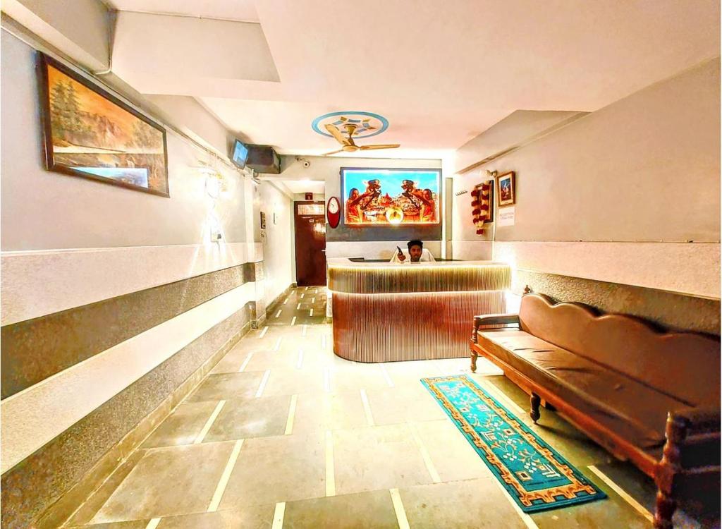 a lobby with a waiting room with a couch and a television at Trinetra Nirvana in Varanasi