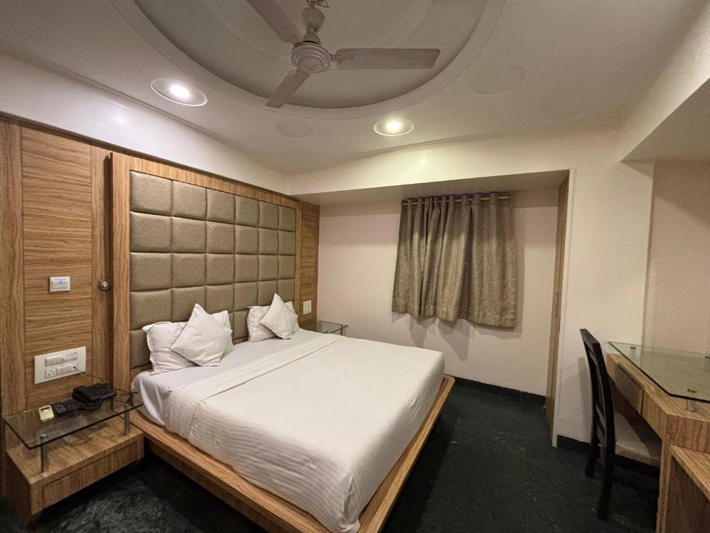 1 dormitorio con cama, mesa y techo en Hotel Sahar Garden Near Mumbai International Airport, en Bombay