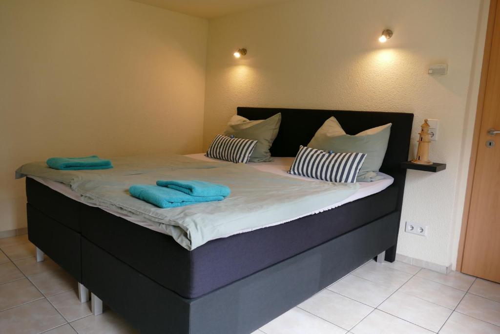 - un grand lit avec 2 serviettes bleues dans l'établissement Ferienhaus Frida, à Samtens