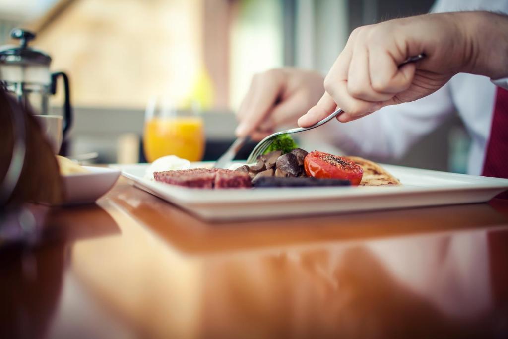 a person eating a plate of food on a table at Carlton George Hotel in Glasgow