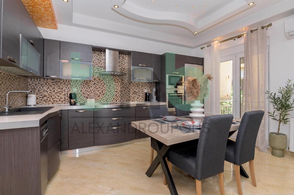 a kitchen with a wooden table and chairs and a dining room at Premium 2 BR Apartment in Alexandroupoli