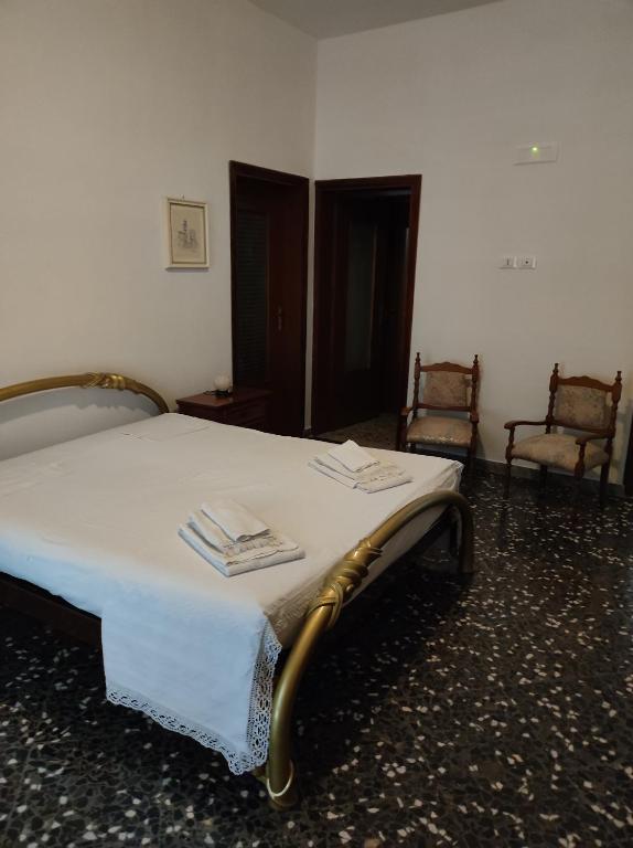 a bedroom with a white bed with two chairs at Sognando Ostuni in Ostuni
