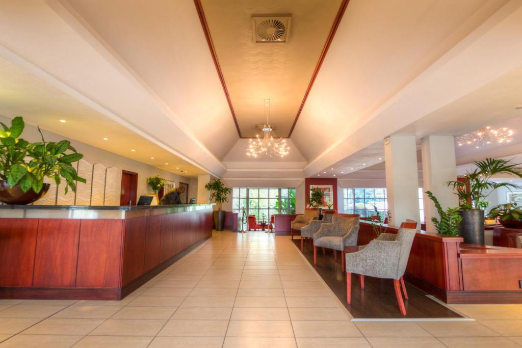 a lobby of a hotel with a bar and chairs at City Lodge Hotel Sandton, Morningside in Johannesburg