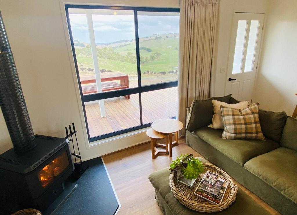 un salon avec un canapé et une cheminée dans l'établissement Oak Vue cottage, à Korumburra