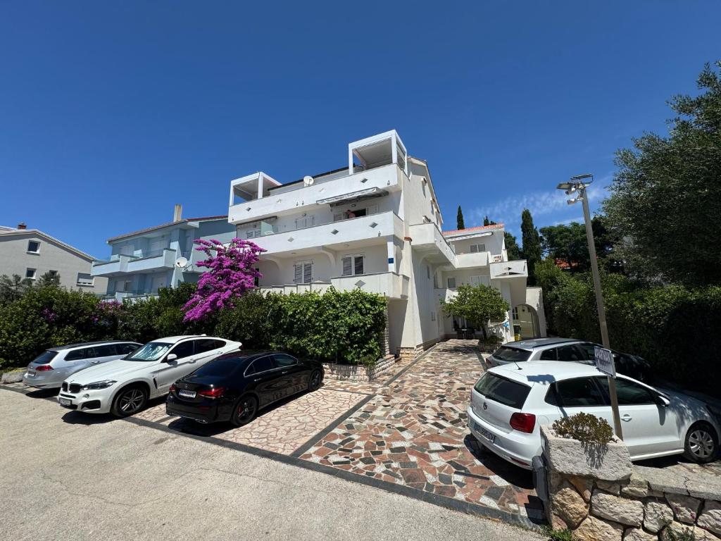 a group of cars parked in front of a building at Emanuela 2 in Novalja
