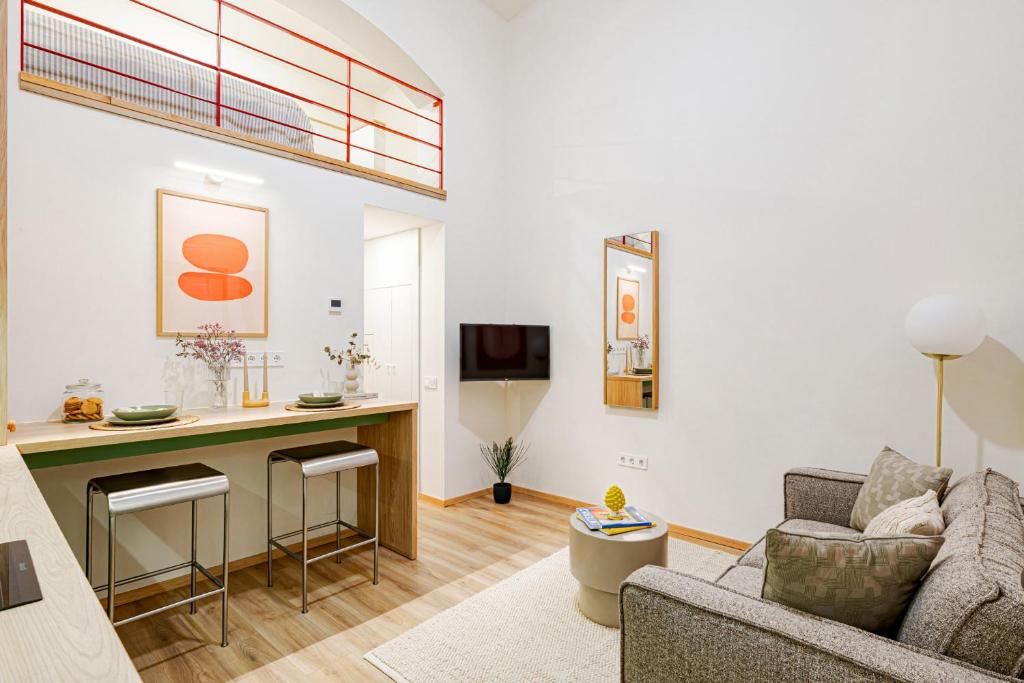 a living room with a couch and a kitchen with a counter at Castle District Design Studio in Budapest