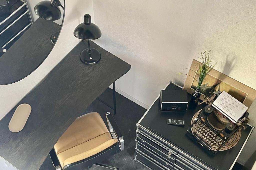 un bureau avec un bureau avec une chaise et une machine à écrire dans l'établissement Turmquartier Weinsberg, à Weinsberg