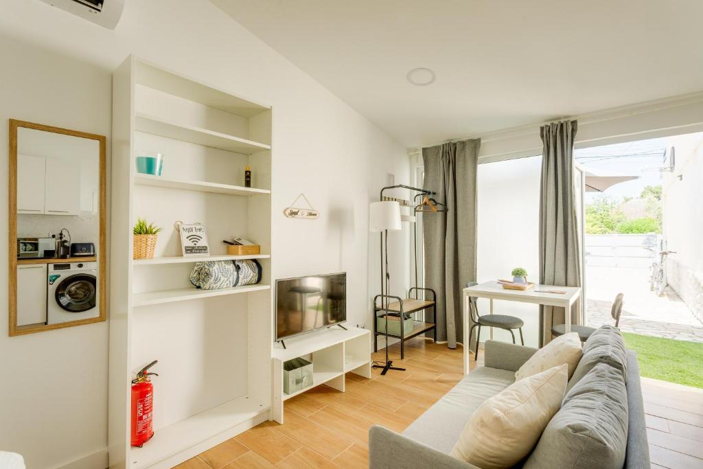 a living room with a couch and a table at Charming Aroeira Beach Studio in Aroeira