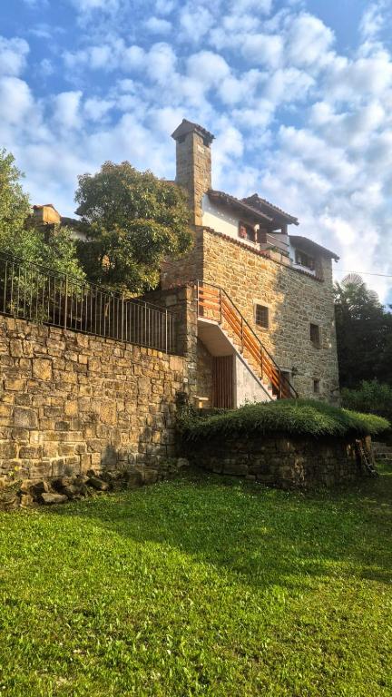 a brick building with a fence and a stone wall at Holiday House Calla, house with a view, near Piran in Sečovlje