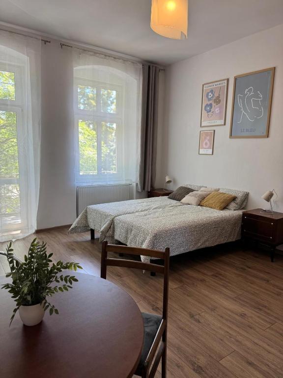 a bedroom with two beds and a table at Pokoje u Bolka Świdnickiego in Świdnica