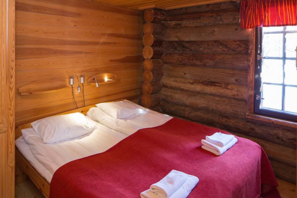 Un dormitorio con una cama en una cabaña de troncos en Holiday Club Ruka Cottages, en Oivanki
