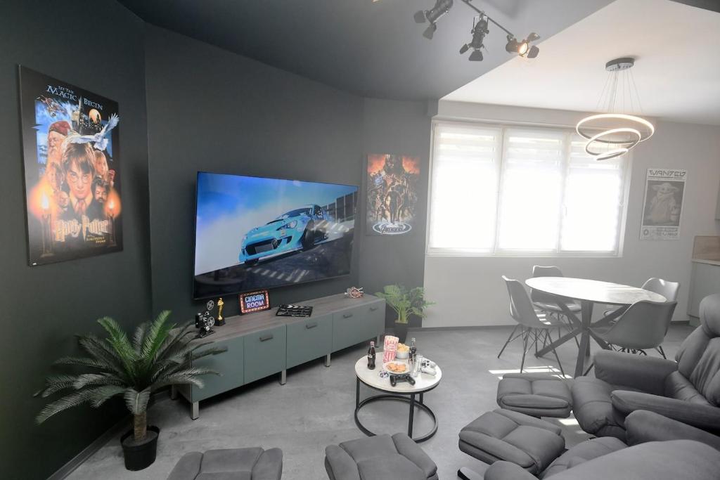 a living room with a flat screen tv and a table at Studio 68, appartement 4personnes in Saint-Louis