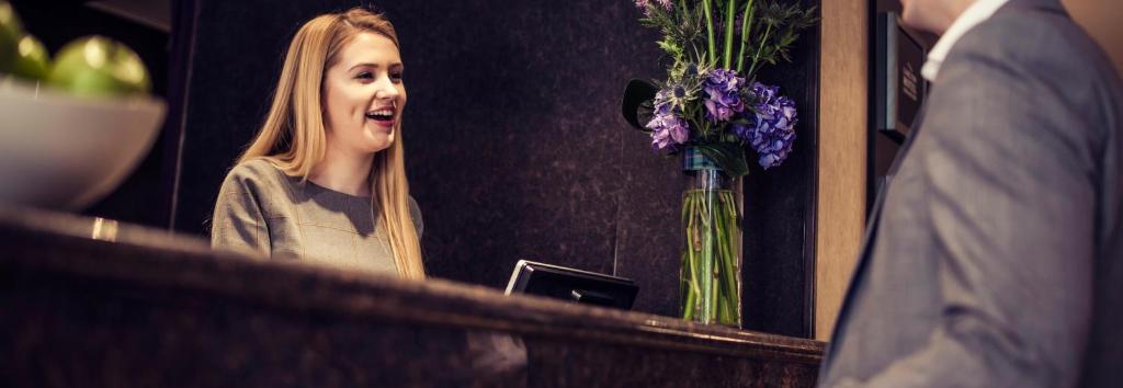a young girl is laughing in front of a mirror at Carlton George Hotel in Glasgow