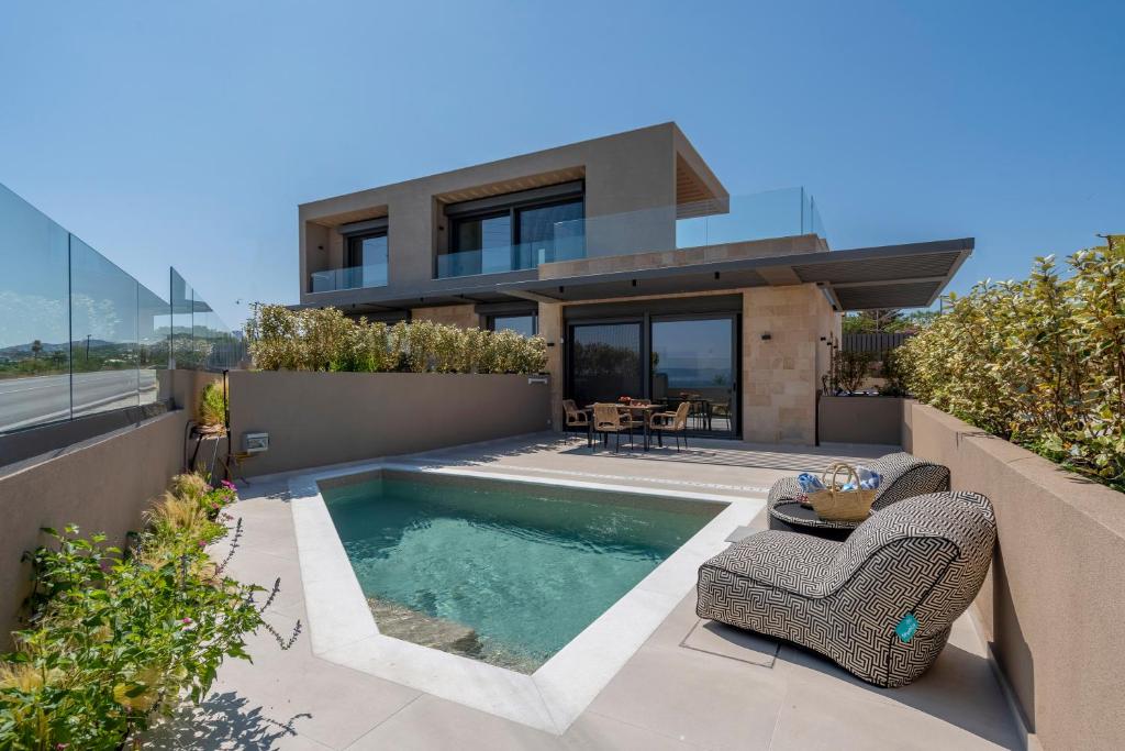 a house with a swimming pool in front of a house at Elements Collection in Khlóï