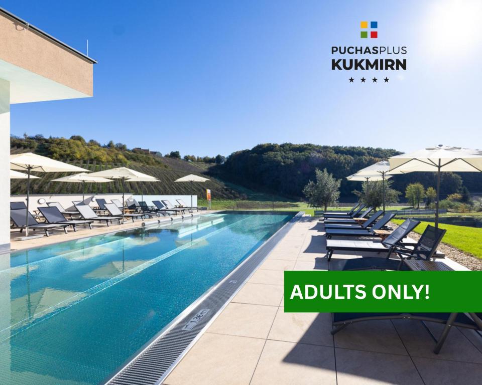 an image of a swimming pool with chairs and umbrellas at Genuss- und Wellnesshotel Puchas Kukmirn in Kukmirn