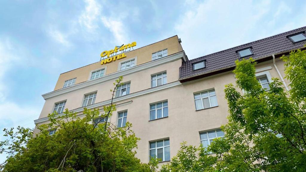 a tall building with a yellow hotel sign on it at Optima Sumy in Sumy