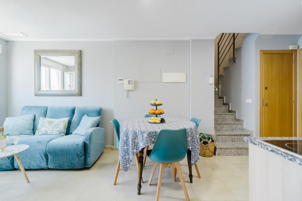 a living room with a blue couch and a table at Chillout Grau de Gandia- attico para 6 personas dos banos VT-44956-V in Gandía