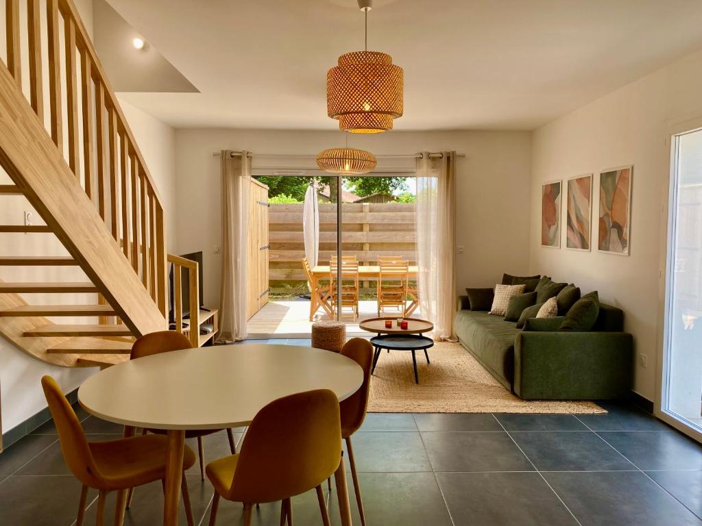 - un salon avec une table et un canapé vert dans l'établissement Maison Alba, à Lit-et-Mixe