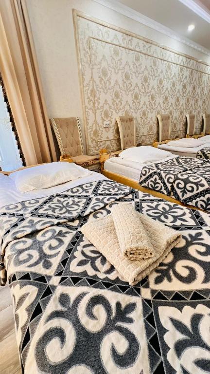 two beds sitting next to each other in a room at Guest House Ormon in Ak-Muz