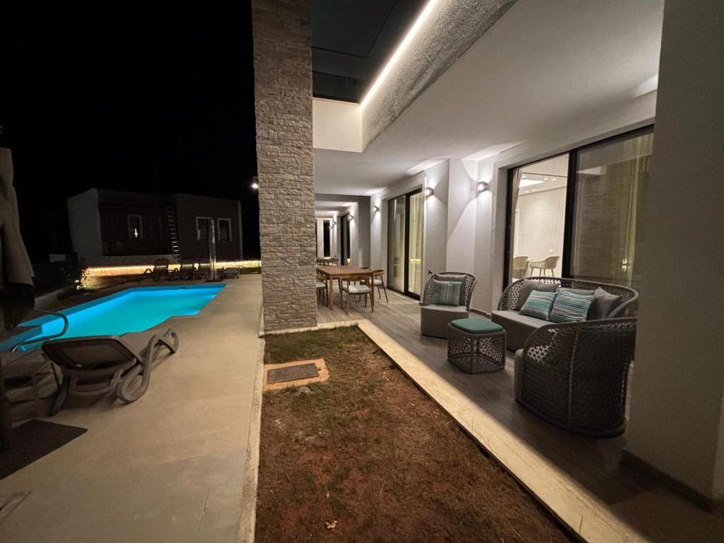 a living room with a swimming pool at night at Turquoise Pool Side Thymus Resort in Himare