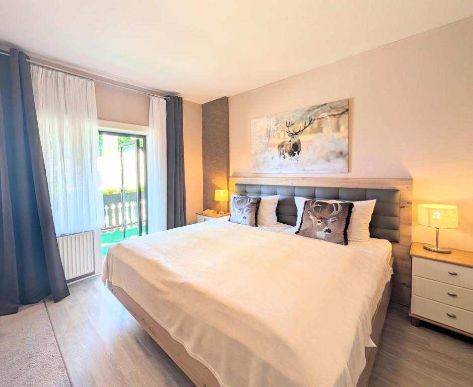 Un dormitorio con una gran cama blanca y una ventana. en Zimmer Nr 4 im Haus Sabine, en Braunlage