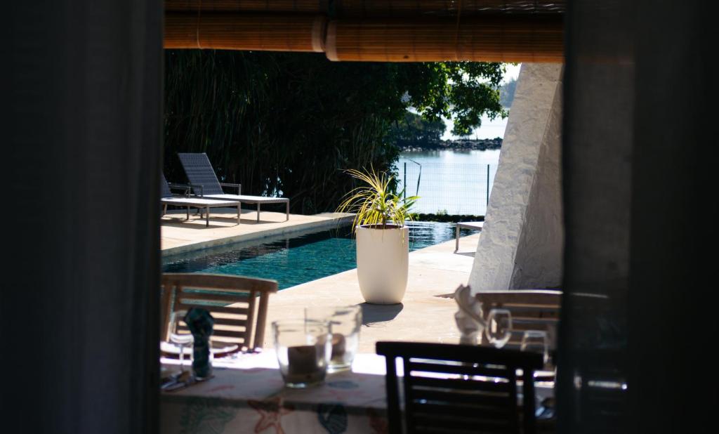 a patio with a table and chairs next to a pool at Villa Opale in Trou d'Eau Douce