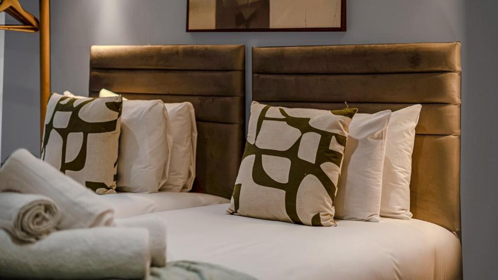 a bedroom with two beds with pillows at Stylish Studio in Heart of London- Great Transport in London