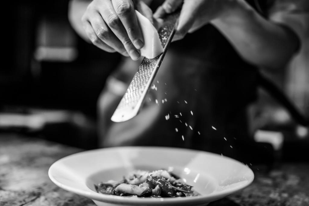 a person with a spatula and a bowl of food at Carlton George Hotel in Glasgow