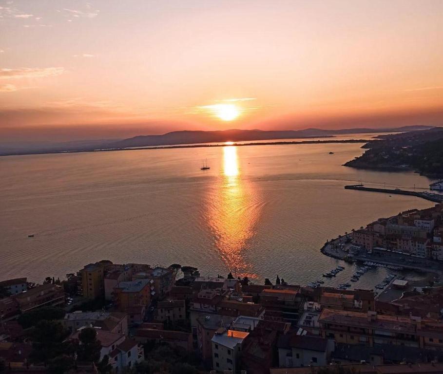 une vue aérienne sur une ville avec le coucher de soleil sur l'eau dans l'établissement Argentario IL SOLE, à Porto Santo Stefano