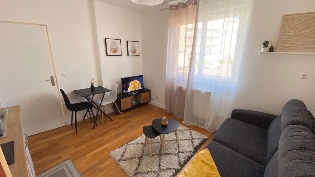 un soggiorno con un divano e un tavolo di Les studios du Cercle a Limoges