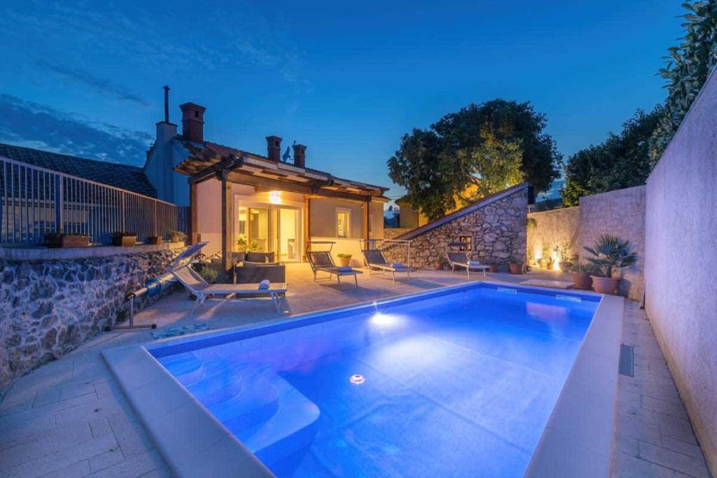 a swimming pool in front of a house at Villa Milla by aneo travel in Novi Vinodolski