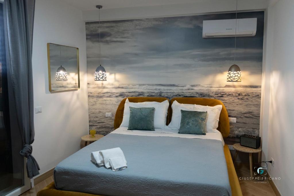 una camera da letto con un letto e un dipinto sul muro di ESSE Homes Sant Elia a Santa Flavia