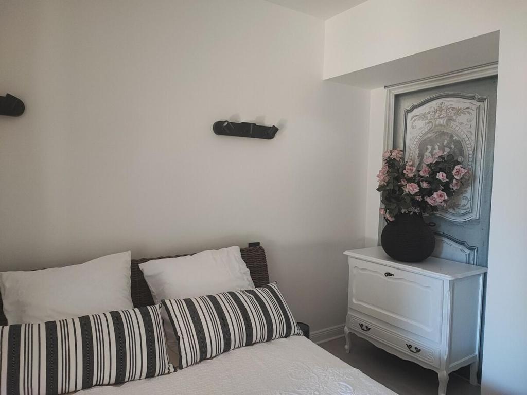Un dormitorio con una cama y una mesa con un jarrón de flores. en Charming house, en Aytré