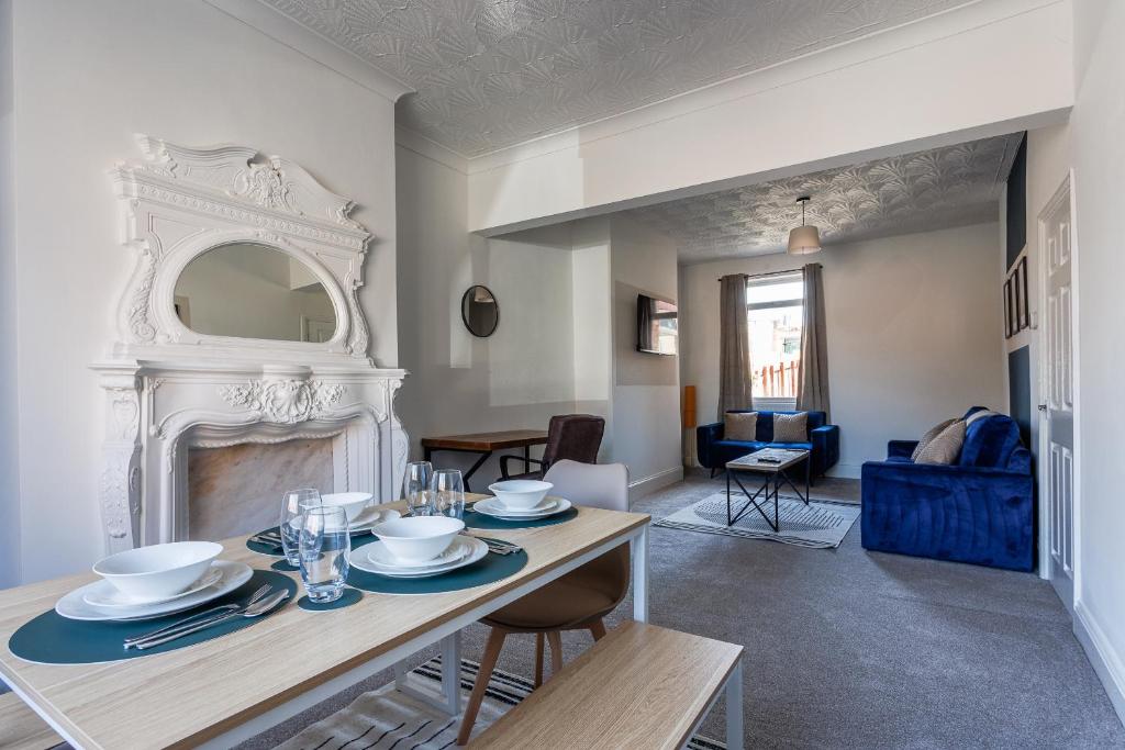 a living room with a table and a fireplace at Spacious 2 bedroom with dining room in Stockton-on-Tees