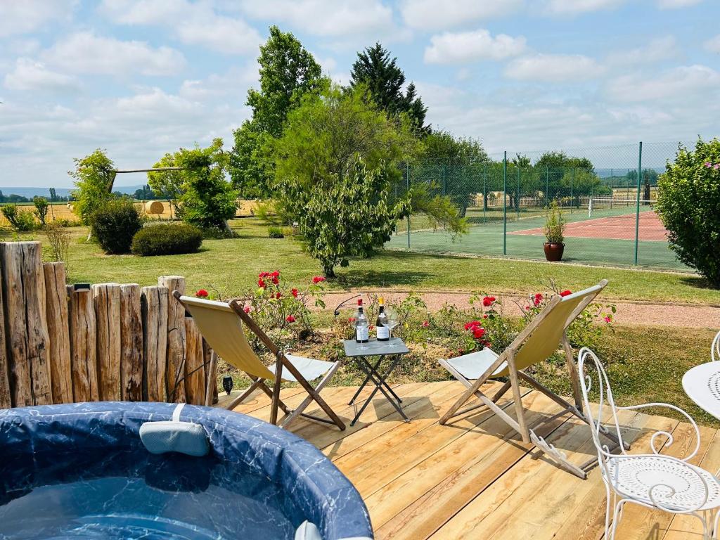 a backyard with a pool and chairs and a table at Au clos des sens in Demigny
