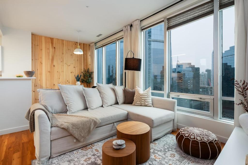 a living room with a couch and large windows at Chic Downtown Apartment with City Views near Stanley Park in Vancouver