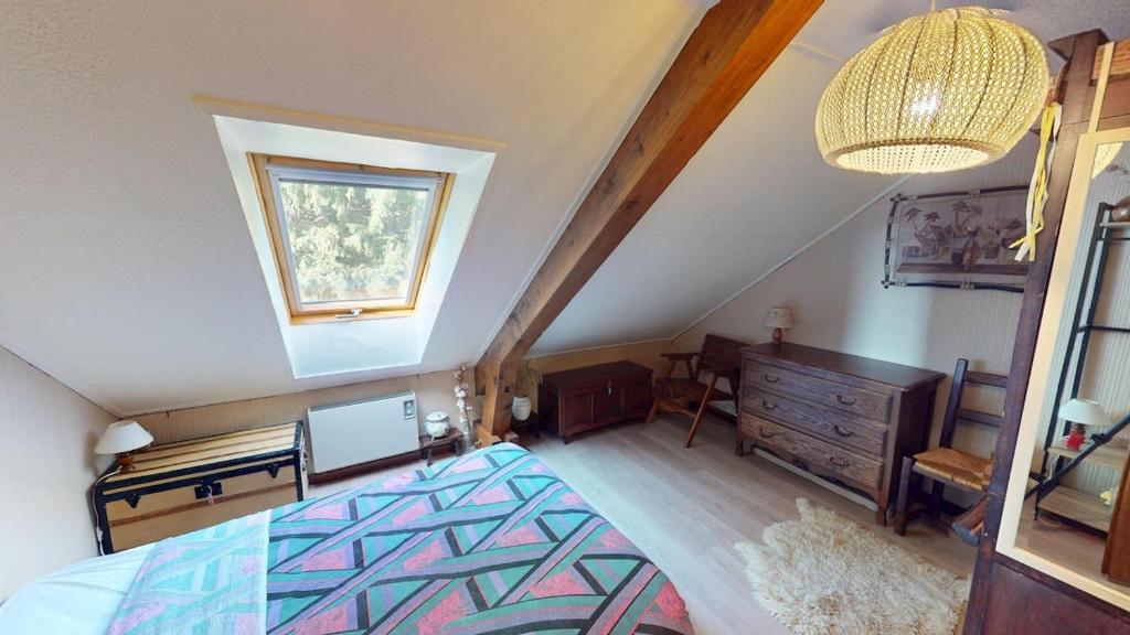 ein Schlafzimmer mit einem Bett, einer Kommode und einem Fenster in der Unterkunft Escapade Familiale en Montagne in Métabief
