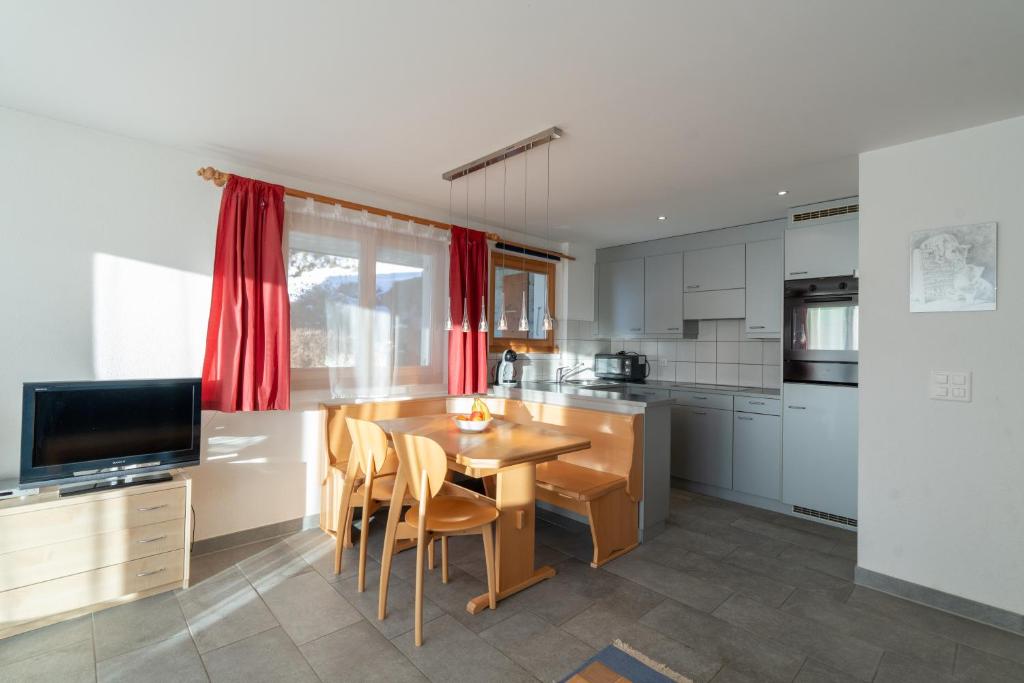 a kitchen with a wooden table and a dining room at Chalet Capricorn in Bettmeralp