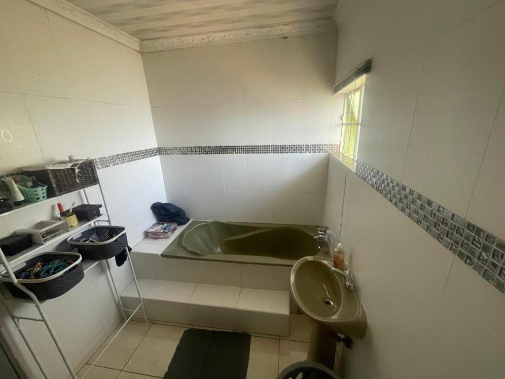 a bathroom with a tub and a toilet and a sink at Innovative Hospitality in Gaborone