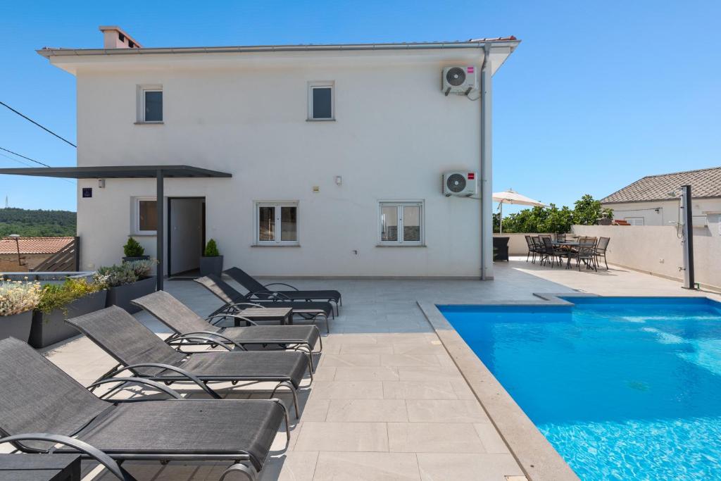 a patio with lounge chairs and a swimming pool at Villa Marko by aneo travel in Ledenice