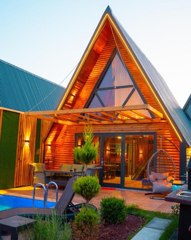 una casa di legno con patio e piscina di Berra Resort Tatil Köyü a Eskiömerler