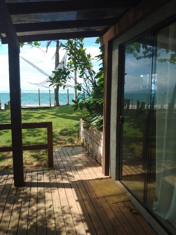 - une porte menant à une terrasse couverte avec vue sur l'océan dans l'établissement Casa em Canasvieiras - Beira mar, à Florianópolis