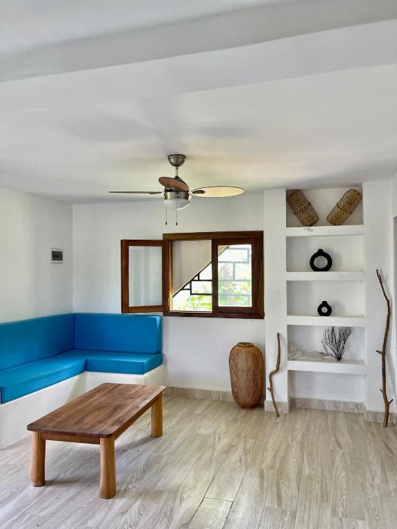 a living room with a blue couch and a table at Le petit relais 2 in Nosy Be