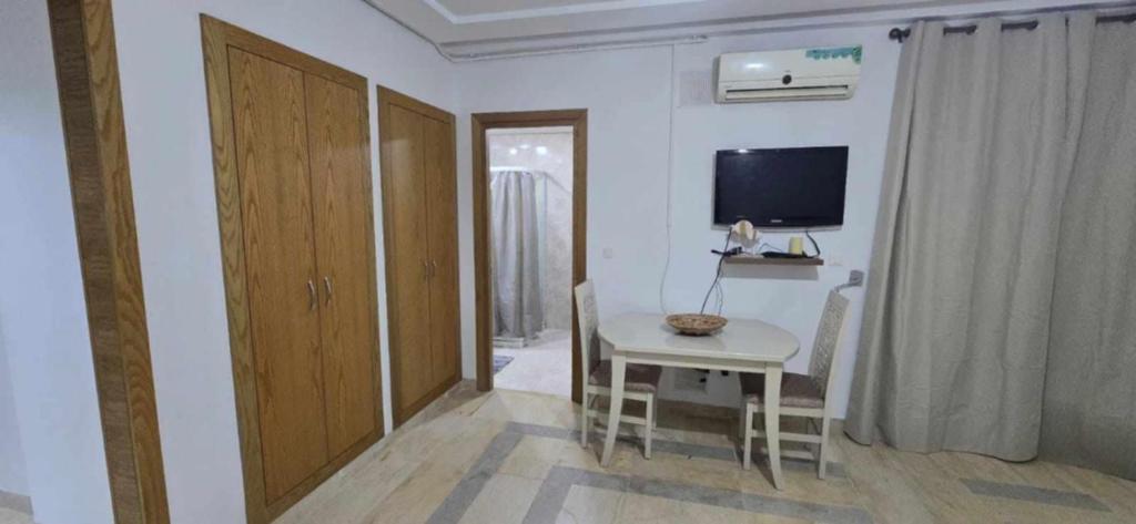 Zimmer mit einem kleinen Tisch und einem TV an der Wand in der Unterkunft Oumaima in Sidi Daoud