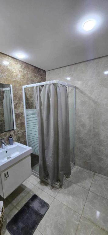 ein Badezimmer mit Dusche und Waschbecken in der Unterkunft Oumaima in Sidi Daoud