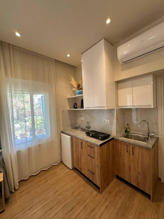 a kitchen with white cabinets and a sink and a window at EYTYXHS Studios in Palaiochora